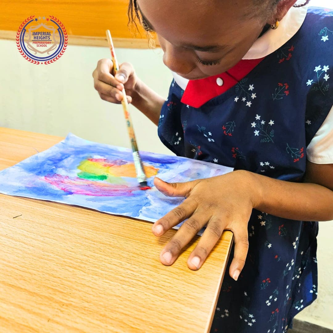A pupil brushing colour across her painting