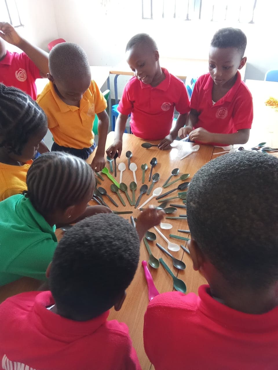 Children assembling a peacock from painted paper feathers