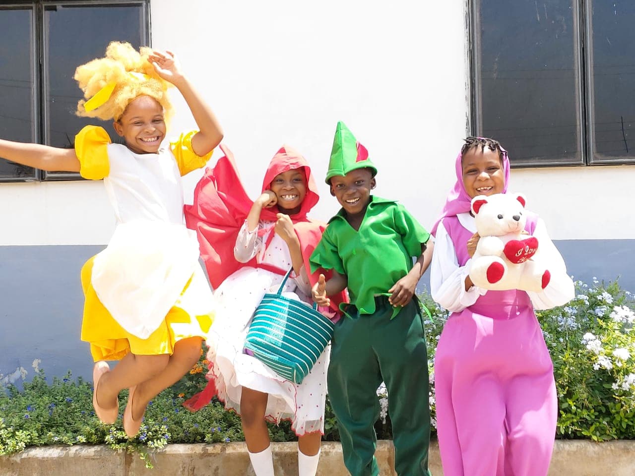 Pupils jumping for the camera in their storybook costumes