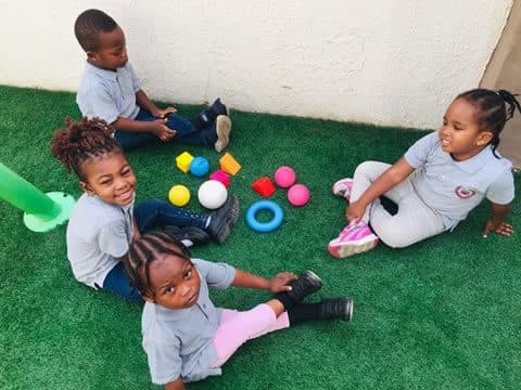 Early Years children playing together on the turf