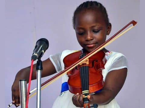 A pupil playing the violin at music club