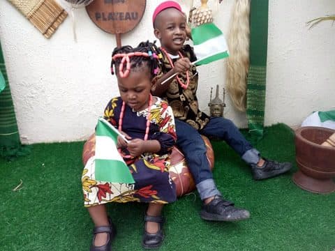 Pupils in traditional dress with the national flag