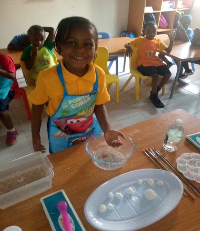 A pupil in an apron preparing ingredients