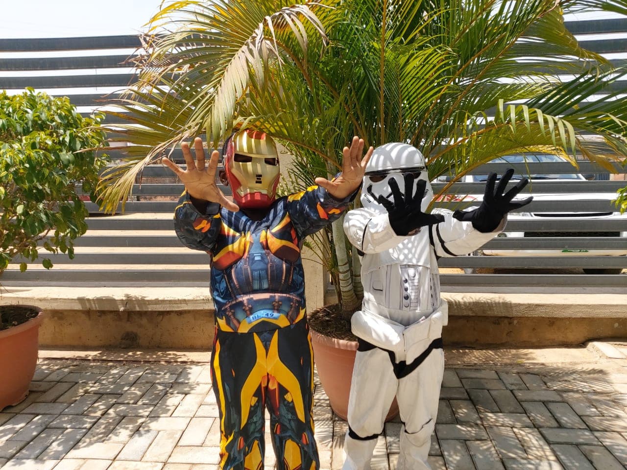 Two costumed mascots waving to the children on the school forecourt