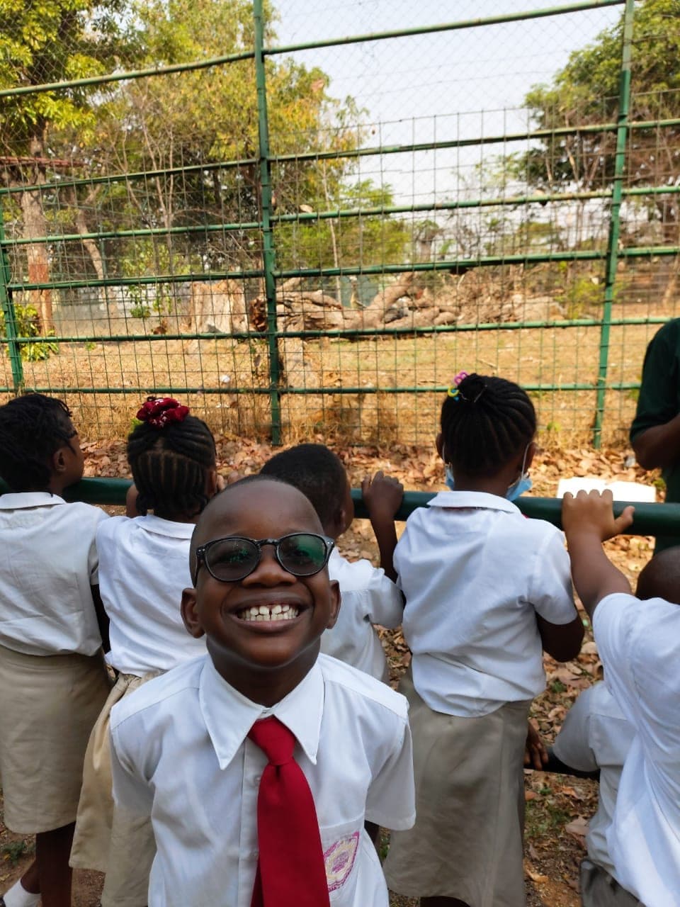 A pupil grinning at the camera during break with his classmates