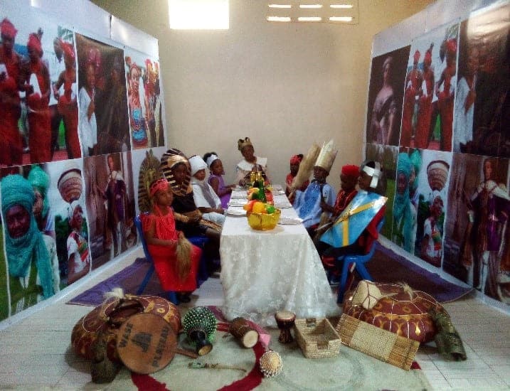 The Cultural Day exhibition table, set with carved masks, beadwork and woven cloth