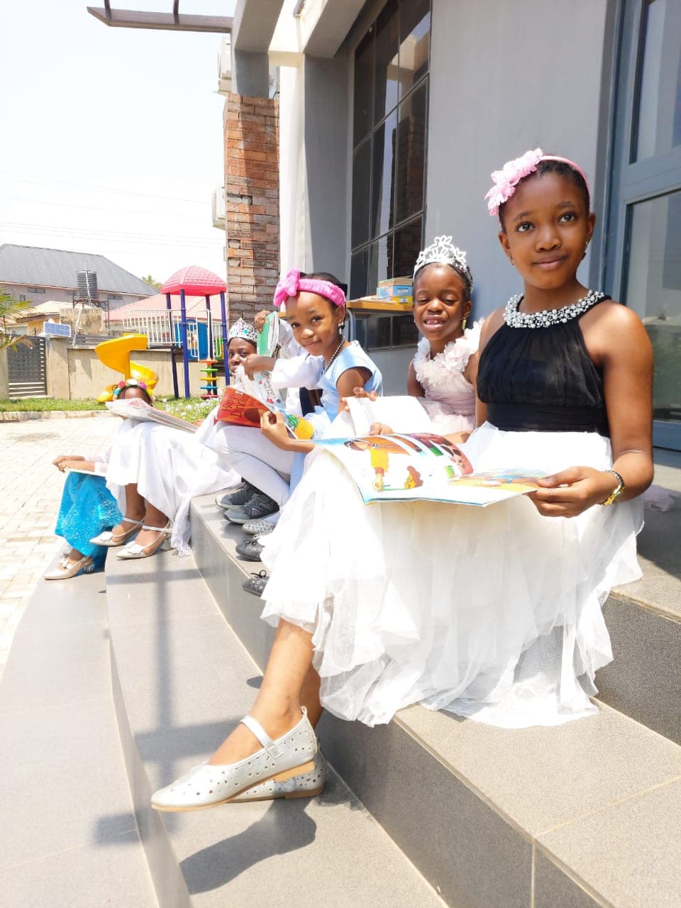 Pupils in traditional dress seated together on the school steps on Cultural Day