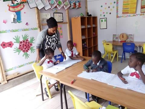 A teacher moving between desks during a lesson