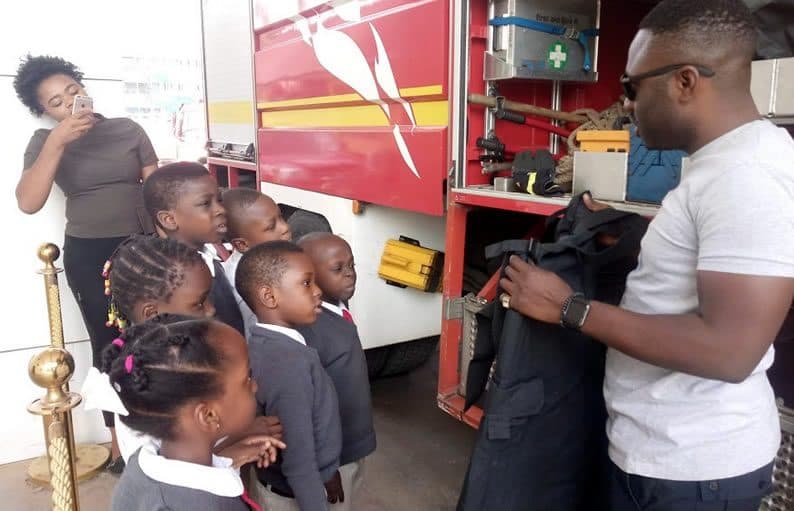 A firefighter showing pupils the equipment
