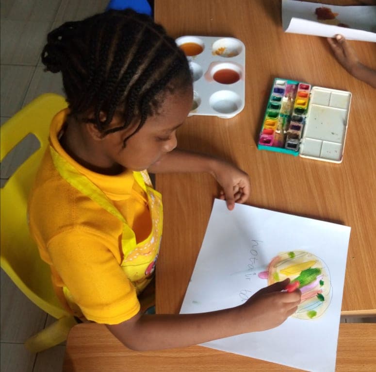 A pupil concentrating on her colouring at the classroom table