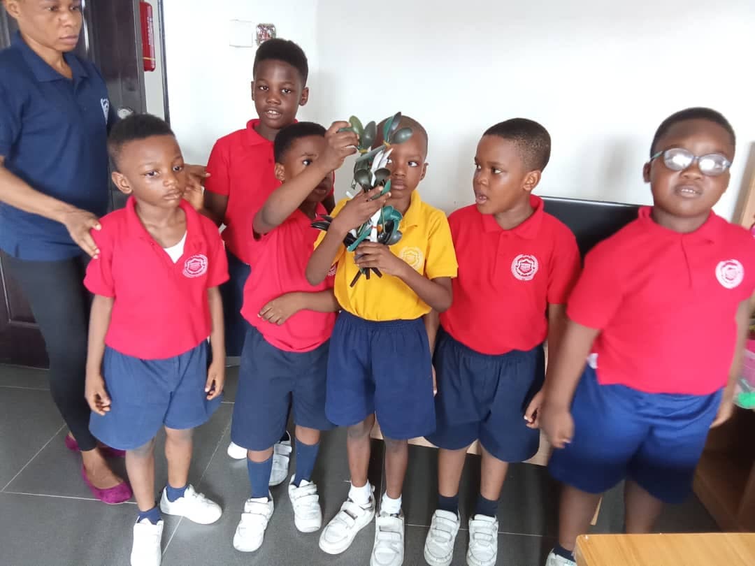 Early Years pupils gathered round a classmate showing the model he has made
