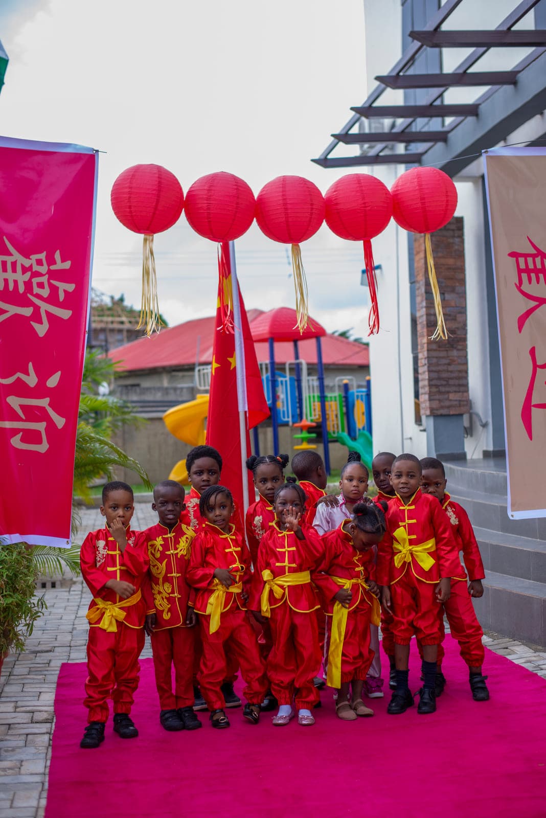 The Cultural Day cast gathered under the lanterns, flag raised behind them