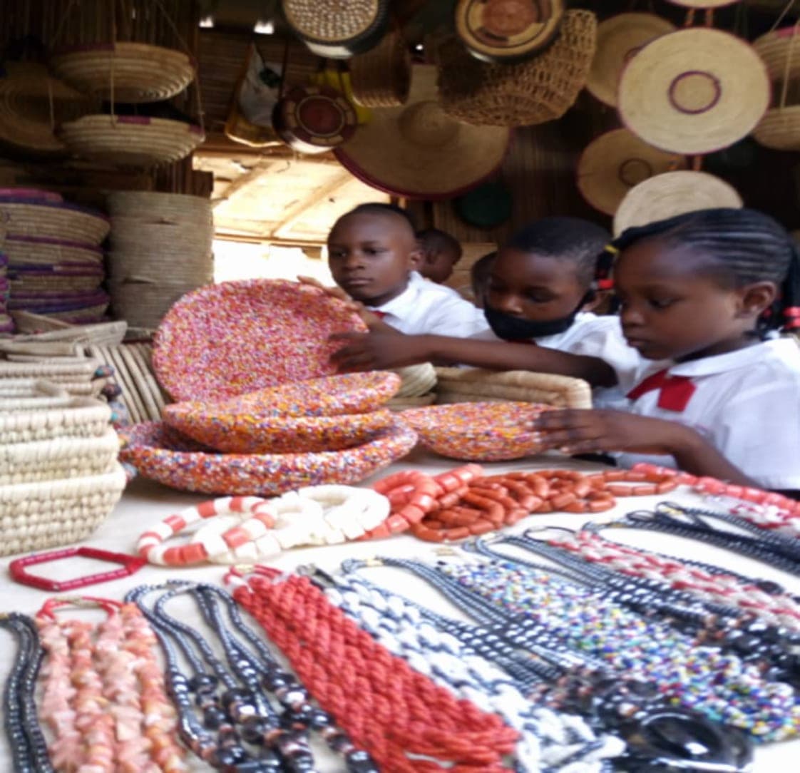 Children examining beadwork on a visit to the craft market
