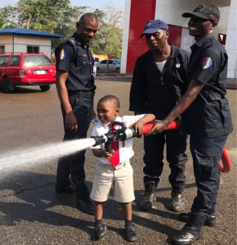 A pupil holding the hose with firefighters during our visit to the fire service