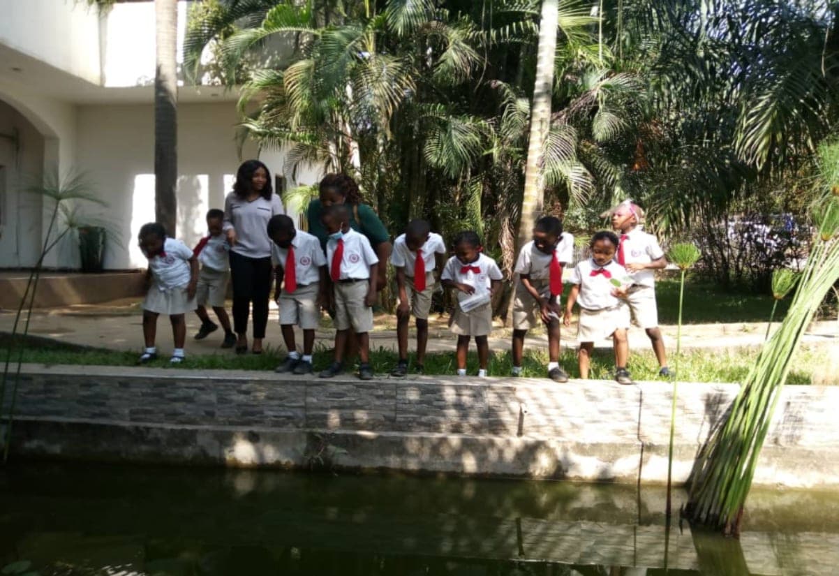 A class walking beside the water on a garden excursion