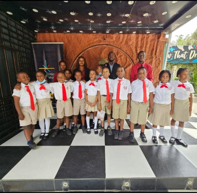 A class photographed with their teachers in the museum foyer