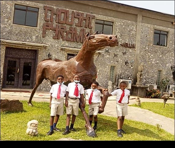 Pupils posing beside the horse sculpture on a visit to an art museum