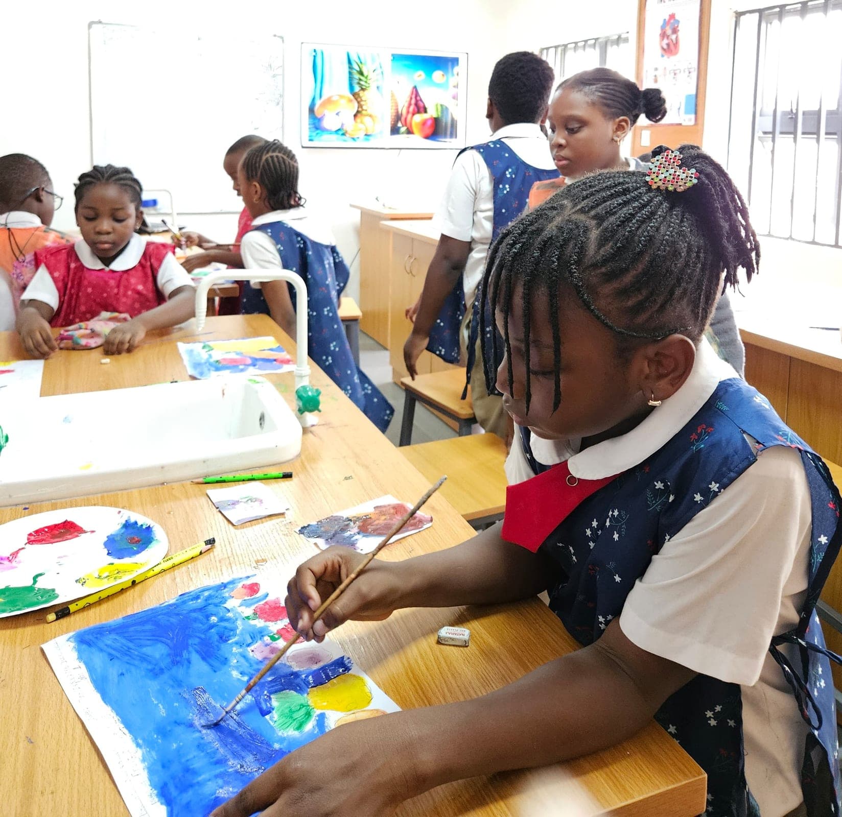 Pupils painting at their easels during an art lesson