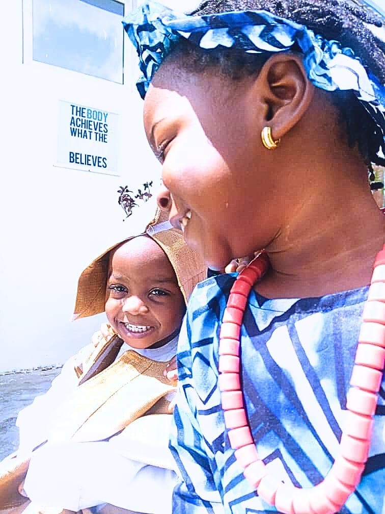 A teacher holding a smiling pupil in her arms
