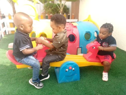 Crèche children playing together on the rocking toys
